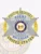 Silver metal 6-point star badge enclosed in a gold circular banner for Delaware fugitive recovery agents, displaying blue lettering "FUGITIVE RECOVERY AGENT UNITED STATES" around the edge, the Delaware state seal centered inside the star, personalized "JANE SMITH 2345671," with a safety pin fastener.