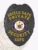 A beautifully designed black badge shaped like a shield, featuring a rich texture that enhances its overall appeal. The phrase "SHIELD SAFE PRIVATE SECURITY" is prominently displayed at the top in golden lettering, complemented by a central emblem that reads "STATE OF NEW JERSEY." Below this, the abbreviation "SSPS" is showcased clearly. This custom metal badge for private security in black with safety pin attachment merges elegance with practical use.