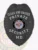 A sleek black badge shaped like a shield, featuring a textured surface that enhances its modern design. The phrase "CLOAK AND DAGGER" is prominently displayed at the top in bold white lettering, while "PRIVATE SECURITY" is showcased in the center. A circular emblem features "STATE OF MARYLAND," surrounded by decorative elements, and below, the abbreviation "MD" is clearly marked. This custom metal badge for private security in black with safety pin attachment combines professionalism with a contemporary look.