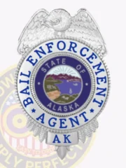 Bail enforcement agent badge made of polished silver metal featuring a silver eagle perched atop, blue text "Bail Enforcement Agent" encircling the Alaska state seal, with "AK" at the bottom, fastened by a safety pin attachment.