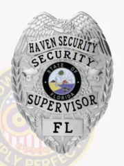 A custom metal badge for a security supervisor, shining in silver. The top displays "HAVEN SECURITY" in bold black text, while "SECURITY SUPERVISOR" is featured below, encircling an emblem that highlights Florida’s state symbol. The badge includes decorative eagle wings and is secured with an effective safety pin attachment for dependable wear.