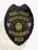 Featuring a striking black finish, this custom metal badge for security guard prominently displays "NOBEL GUARD SECURITY" in eye-catching gold letters at the top. Beneath that, "PRIVATE SECURITY" and "NGS" are also rendered in gold, surrounded by intricate detailing and two American flags. The Vermont state seal takes center stage, symbolizing authority, while the safety pin attachment ensures easy fastening.