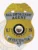 Bail enforcement agent shield badge made of gold metal with a gold eagle at the top, silver panels inscribed with "Bail Enforcement Agent" and "Investigator AZ," a central Arizona state seal, and blue letters "U" and "S" on either side, fastened by a safety pin.