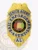 Custom bail enforcement agent badge featuring a gold eagle at the top, silver side panels with black text "Senior Agent" and "Bail Enforcement Agent," central colorful Alabama Great Seal, and "AL" at the bottom, attached using a safety pin.