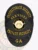 This custom metal badge for private security features a sleek black design with bold gold lettering. The top reads "PROTECTORATE SECURITY," while the center showcases the state seal of Georgia. Below, "PRIVATE SECURITY" is prominently displayed, and "GA" is featured at the bottom. The badge includes a reliable safety pin attachment for secure wear on uniforms.