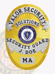 Designed as a custom metal badge for security guard, this gold badge highlights impressive silver panels and intricate detailing throughout. The badge showcases "VALOR SECURITY" in bold letters, with "SECURITY GUARD J. DOE" presented beneath the Massachusetts state seal, emphasizing professionalism and authority.