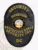 This polished black custom metal badge for security supervisors features "SECURITY" prominently at the top in striking yellow letters. The badge displays "SUPERVISOR," along with a central emblem highlighting the District of Columbia. Adorned with the text "PROTECTIVE FORCE SECURITY INC." and "DC," this badge is secured with a reliable safety pin attachment for dependable wear.