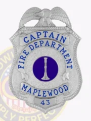 Personalized silver firefighter captain badge from Maplewood Fire Department, showcasing an eagle at the crest, blue text โCAPTAIN FIRE DEPARTMENT MAPLEWOOD 43โ encircling a blue circle with a silver bugle in the center, attached by a safety pin.