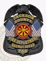 Black metal shield badge for Jackson County Fire Dept. Hazmat Squad, with a detailed black eagle perched atop, gold lettering on black ribbons stating "JACKSON COUNTY," "FIRE DEPARTMENT," "HAZMAT SQUAD," and badge number "768," flanked by American flags and a red fire service emblem in the middle.