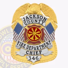 Jackson county fire dept. Chief badge crafted in gold metal with a large gold eagle atop, white scrolls featuring black text "jackson county," "fire department," and "chief," number 346 below, a red fire service symbol in the center, and american flags on the shield’s edges.