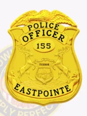 Bright gold metal police badge designed for Eastpointe Police Dept., featuring a detailed eagle on top of a polished shield, bold black lettering of "POLICE OFFICER," officer number "155" inside an oval, and "EASTPOINTE" at the bottom, fitted with a safety pin for secure attachment.