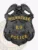 Milwaukee Police Dept. custom black metal badge with an eagle at the top, bold yellow lettering displaying MILWAUKEE on the upper banner and POLICE on the lower banner, with a central black star featuring K9 in the middle, designed with a safety pin fastener.
