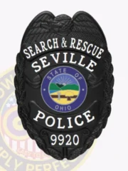 Seville Police Search & Rescue custom black metal badge with an eagle perched above the shield shape, white text SEARCH & RESCUE, SEVILLE, and POLICE on curved banners, a colorful State of Ohio round emblem in the center, and the number 9920 at the bottom, equipped with a safety pin attachment.