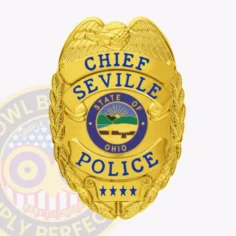 Seville police dept. Chief custom gold metal badge with an eagle perched on top of a gold shield, blue lettering for chief, seville, and police arranged on banners, a central round emblem showing the state of ohio seal, and four blue stars at the base, secured by a safety pin.