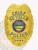Gold metal badge for Seville Police Department Chief showing a raised eagle atop the shield, blue banners with bold text CHIEF, SEVILLE, and POLICE, a colorful Ohio state seal in the center, and four blue stars near the bottom, designed with a safety pin attachment.