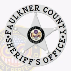Detailed silver 5 point star metal badge for faulkner county sheriff’s office, surrounded by a white circular text banner in black and centered state of arkansas seal, designed for secure safety pin attachment.
