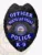 North Las Vegas Police K-9 officer badge in black metal with a raised eagle on top, accented by blue reverse enamel banners stating Officer, North Las Vegas, Police, and K-9, centered around the Nevada state seal, featuring a safety pin for secure attachment.