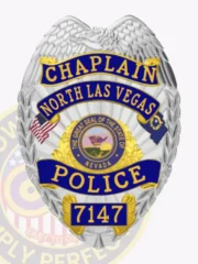 Metal badge in silver color featuring an eagle at the top and blue reverse enamel sections showing Chaplain, North Las Vegas, Police, and badge number 7147, with the Nevada state seal in the center, created for the North Las Vegas Police chaplain position with a safety pin for secure wear.