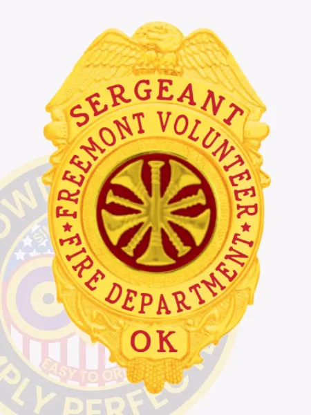 Gold eagle top metal sergeant badge for Freemont Volunteer Fire Dept., displaying red text "SERGEANT FREEMONT VOLUNTEER FIRE DEPARTMENT OK" around a red circle featuring a gold fire horn emblem, designed with a safety pin attachment.
