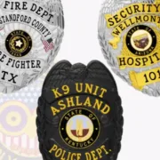 A collection of custom badges showcasing diverse designs, including a silver Fire Department badge from Stanford County, Texas, featuring an eagle emblem and American flags. Next to it, a golden Security badge from Wellmont Hospital in Arizona with intricate detailing. The third badge is a black K9 Unit badge from Ashland, Kentucky, emphasizing its law enforcement connection. Discover these unique custom badges at the All Badges Shop for personalized police and law enforcement needs.