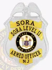 Close-up image of a custom silver metal badge for SORA Level II armed officer, showing gold panels with black embossed text, a raised eagle at the top, the State of New Jersey seal in the center, and "NJ" at the bottom.