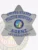 Law enforcement badge in silver, designed as a 6-point star with 'United States Fugitive Recovery Agent' text and the State of California seal at the center. The badge includes an agent number 6789012345 and features a safety pin on the back for attachment.