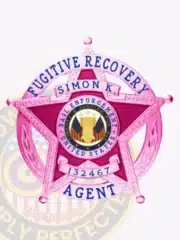 Law enforcement badge crafted in custom BCAM pink metal, featuring a 5-point star inside a circular banner that reads 'Fugitive Recovery Agent.' The badge is personalized with 'Simon K.' and agent ID 132467, with a safety pin attachment and the official Bail Enforcement United States seal in the center.