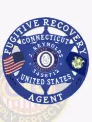 Custom blue Autism Awareness themed metal badge for Fugitive Recovery Agents, featuring a 6-point star inside a circular banner. The badge shows the State of Connecticut seal at the center, flanked by U.S. and Connecticut flags, personalized with J. Reynolds and agent number 3456712, with safety pin attachment.