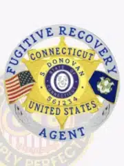 Custom gold 6-point star metal badge with a silver circular banner for Fugitive Recovery Agent. The badge is personalized with the name S. Donovan and agent number 561234, featuring the State of Connecticut seal in the center, flanked by American and Connecticut flags, with a safety pin attachment.