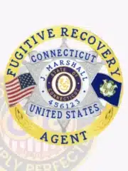 Custom silver 6-point star metal badge with a gold circular banner for Fugitive Recovery Agent, personalized with the name J. Marshall and agent number 456123. The badge features the State of Connecticut seal in the center, flanked by the United States and Connecticut flags, with a safety pin attachment.
