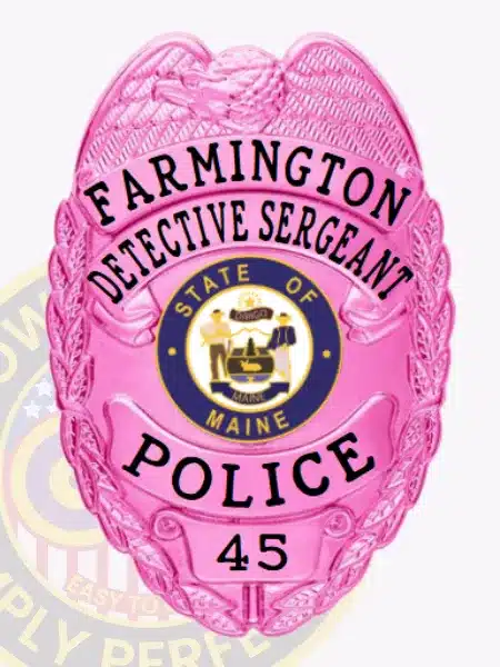 Pink Farmington Police Detective Sergeant badge made from metal, showing a detailed eagle design at the top, bold black lettering including "FARMINGTON DETECTIVE SERGEANT" and "POLICE 45," and the official State of Maine seal in the center, equipped with a safety pin for secure attachment.