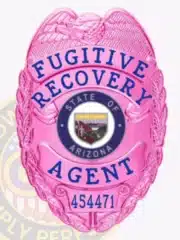 Custom BCAM pink metal badge for Fugitive Recovery Agent featuring an eagle at the top, embossed laurel wreath border, the Arizona state seal in the center with a detailed landscape emblem, blue lettering for "Fugitive Recovery Agent," and identification number 454471, with a safety pin attachment.