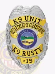 Silver and gold eagle top badge for the Ohio Department of Corrections K9 Unit, displaying the text 'K9 RUSTY #15' on a gold banner, blue Ohio state seal, with a safety pin on the back for secure wear.