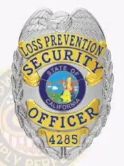 Silver metal badge with gold accents for California Loss Prevention Security Officers, including a raised eagle emblem on top, blue text on gold banners, state seal center, and safety pin attachment.