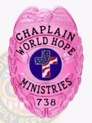 Bright pink Police Chaplain badge for World Hope Ministries, designed with a pink eagle atop, matching pink background, black text around a patriotic cross emblem, and badge number "738," equipped with a safety pin for secure fastening.