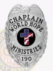 Detailed image of a custom silver metal chaplain badge for World Hope Ministries, including a silver eagle emblem on top, black text reading "CHAPLAIN WORLD HOPE MINISTRIES," a central cross with American flag design inside a blue circle, and badge number "190," with safety pin on the back.
