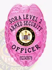 Custom BCAM pink metal badge for SORA Level 2 armed security officer, featuring a detailed eagle at the top, bold black embossed text, the State of New Jersey seal in the center with gold and blue detailing, and a safety pin attachment on the back.