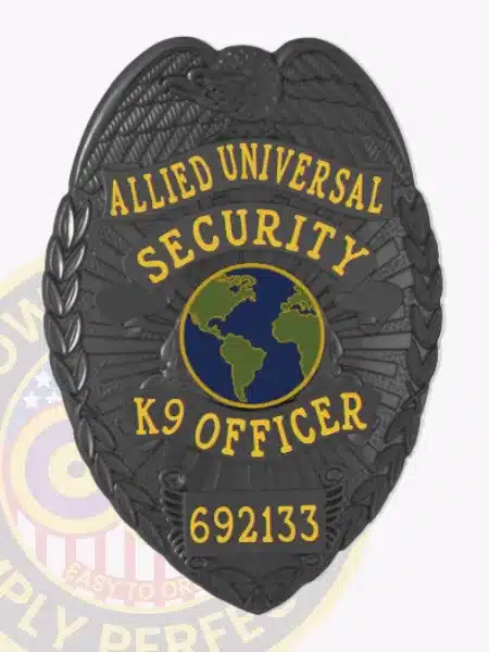 Black metal security badge custom-made for Allied Universal K9 officers, showing a detailed eagle design at the top, a central globe icon in blue and green, bold yellow lettering for "Security K9 Officer," and a safety pin fastener for secure attachment.