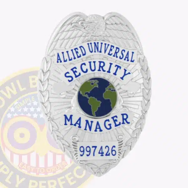 Close-up of a custom silver eagle top metal badge for Allied Universal, featuring an embossed eagle at the top, blue text reading "Allied Universal Security Manager" surrounding a blue and green globe emblem, and badge number 997426, with a safety pin attachment on the back.