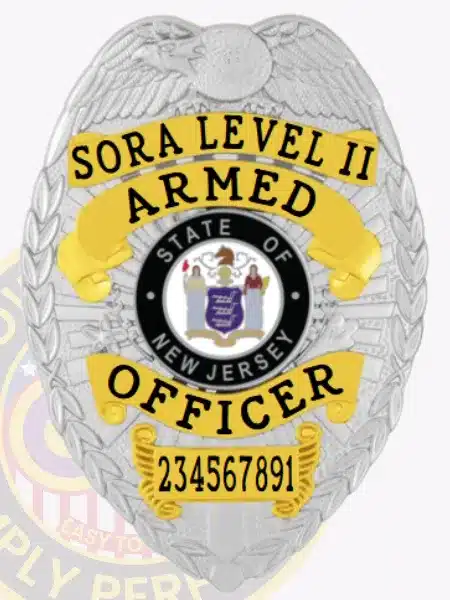 Close-up image of a custom silver metal badge for SORA Level II armed officers, displaying gold panels with black embossed text, an eagle motif at the top, the State of New Jersey seal in the center, and a safety pin attachment on the reverse side.