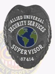 Black metal security badge custom-made for Allied Universal supervisors, showing a bold eagle design at the top, a green and blue globe in the center, clear white lettering for "Security Services Supervisor," and a safety pin fastener on the back for easy attachment.