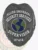 Black metal security badge custom-made for Allied Universal supervisors, showing a bold eagle design at the top, a green and blue globe in the center, clear white lettering for "Security Services Supervisor," and a safety pin fastener on the back for easy attachment.
