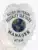 Detailed image of a custom silver eagle top metal badge for Allied Universal, highlighting the textured eagle wings, globe symbol in the center, manager title in bold black letters, and identification number 87416, equipped with a safety pin attachment.