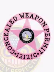 Custom BCAM pink 5-point star metal badge with a circular pink banner reading 'Concealed Weapon Permit' and displaying permit number '12121C', featuring the District of Columbia seal in the center and a safety pin attachment.