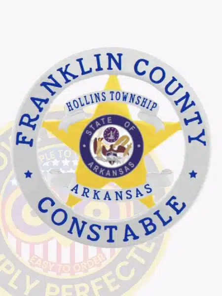Official-looking gold metal badge featuring a five-point star framed by a silver circular band with blue lettering stating "Franklin County Constable," including ribbons with "Hollins Township Arkansas" and the State of Arkansas seal, fitted with a safety pin closure.