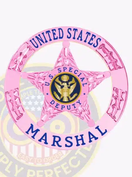 Pink metal US Marshal badge shaped as a 5-point star with 'U.S. SPECIAL DEPUTY' text around an eagle seal in the center, enclosed by a pink ring banner stating 'UNITED STATES MARSHAL,' attached with a safety pin for secure wear.