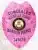 Custom BCAM pink metal badge for concealed handgun permit featuring a detailed eagle design, engraved with "CONCEALED" at the top, personalized name "MICHELLE JOHNS," the Colorado state seal in the center, and "HANDGUN PERMIT" below, numbered 345678, equipped with a safety pin attachment.