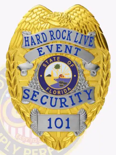 Custom gold eagle top metal badge with silver panels for Hard Rock Live Event Security, featuring blue embossed text 'HARD ROCK LIVE EVENT SECURITY 101' and the colorful State of Florida seal in the center, with a safety pin attachment.
