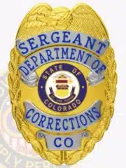 Detailed custom badge showing a gold eagle on top, silver-colored panels with blue text reading "Sergeant Department of Corrections," and a circular Colorado state emblem centered. The badge has a safety pin attachment for secure wear.