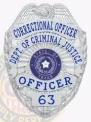Custom-designed silver metal badge with an eagle at the top, inscribed with "Correctional Officer Dept. of Criminal Justice Officer" in blue letters on silver panels, featuring the official Texas state seal in the center and a safety pin attachment.
